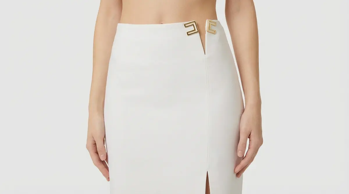 Белая юбка-карандаш Elisabetta Franchi с золотистой пряжкой-логотипом и разрезом, коллекция итальянской моды 2026.